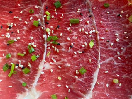Slice thin raw beef sprinkle black sesame seeds and white sesame seeds with sliced spring onionsの写真素材
