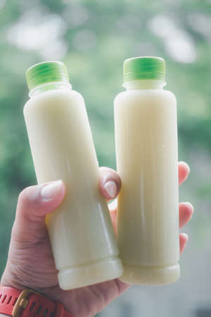 Man holding of two cold guava juice in plastic bottles. Healthy lifestyleの写真素材