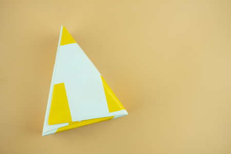 Triangle shape gift box on a yellow backgroundの写真素材