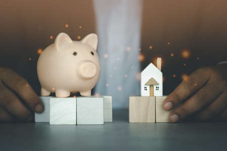 Young business man in suit holding home and piggy bank for planning saving future, insurance agent and credit. Savings for buying home. Economical buy housing.の写真素材
