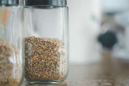 Dried oregano in a glass jar on table in a pizza placeの写真素材