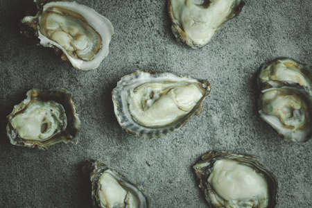 Fresh raw oysters on a black stone background. Top viewの写真素材