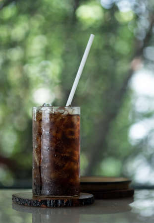Glass cup of soft drink with white straw