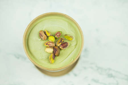 Tasty pistachio ice cream in kraft paper cup. Close upの写真素材