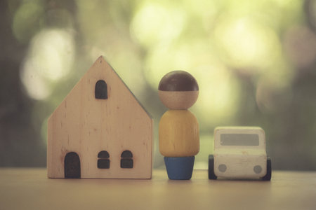 A man with a house and a white car. Concept of mortgage insurance and real estate purchase.