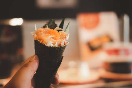 Hand with salmon sushi temaki. Selective focusの写真素材