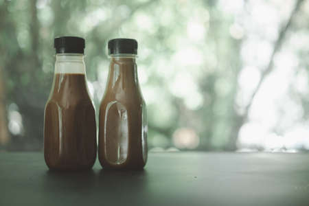 Two bottle of coffee Mocha against nature background.の写真素材