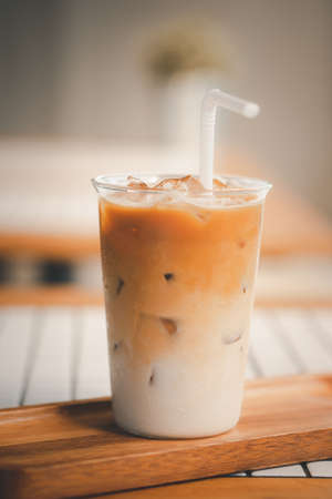 Iced latte coffee on a table inside the cafe during the day.の写真素材