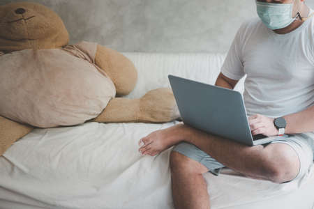 Male wearing a health mask preventing   virus infection  , working from home. In self-isolation. The concept of working from home and social distancing.の写真素材