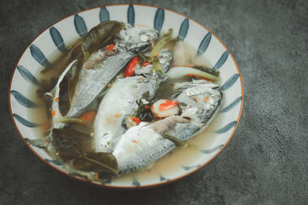Hot and spicy soup of mackerel fish with chilli and local herbal vegetable in the bowl. Famous...