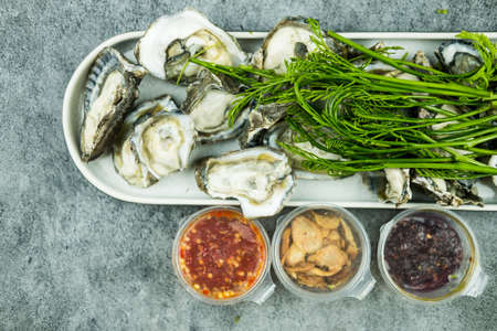 Fresh oyster and dry shallot, garlic, chili, spicy sauce, sweet chili paste, and acacia leaf. Thai...