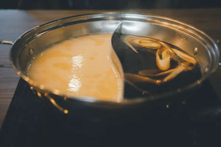 Specially made pot for bouillon base combo option to have two flavors black and mushroom of hot boiling soupsの写真素材