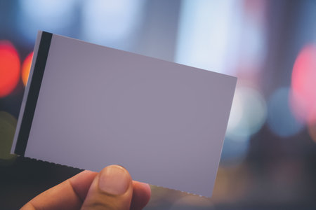 Hands holding an empty white a paper movie ticket. Blank template of ticket that you can create your own design.の写真素材