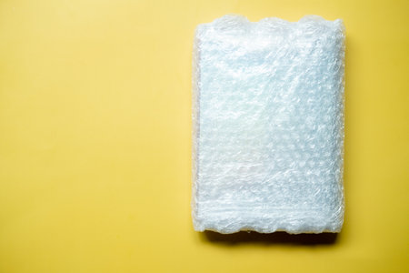 Bubbles covering the box for protection product cracked or insurance during transit on a yellow backgroundの写真素材