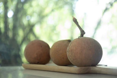 Santol fruits on a wood tray, Santol has a sour taste and the middle of santol is sweeter. It is a...