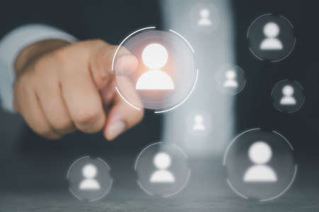 Businessman hand choosing one people icon from many people icons. The concept of human resources conceptの写真素材