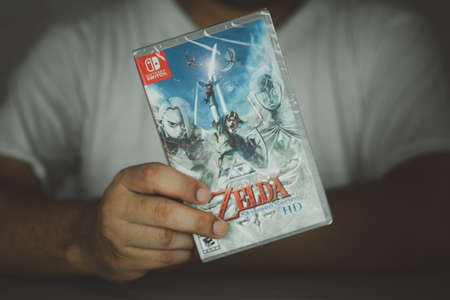 Samut Prakan, Thailand - July 24, 2021 : A man holding Nintendo Switch gaming box of The Legend of...