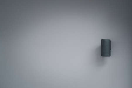 Cylinder black wall lamp on gray wall with copy spaceの写真素材