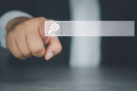 Businessman hand touching magnifying glass icon search. Searching information data on internet networking concept.の写真素材