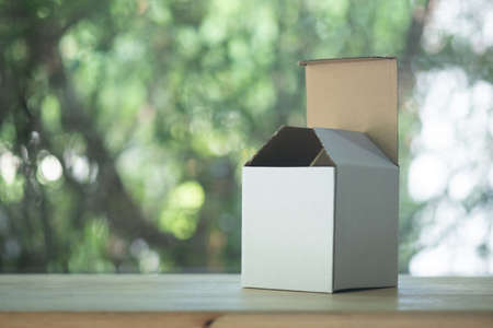 Opened white blank cube box placed on wood tableの写真素材