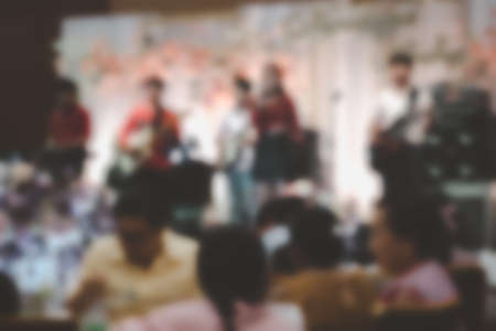 Abstract blurred image of people in wedding ceremony dinner ballroom and musician in stageの写真素材