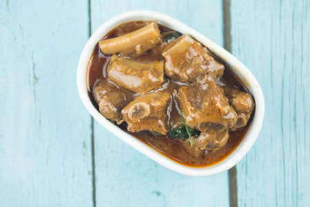 Stew pork ribs in bowl on wood table. Top view