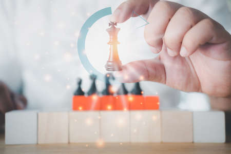 Business man leader of a successful business holding the chess in hand. Business challenge and managementの写真素材