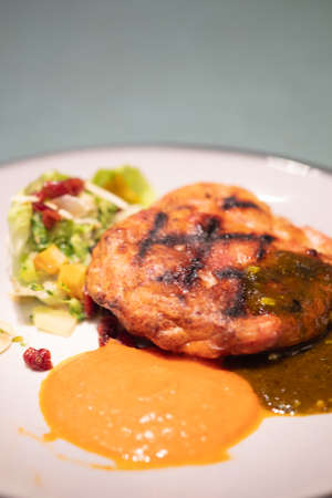 Cooked minced beef patty with vegetables with two sauceの写真素材