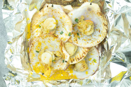 Group of closed up butter grilled scallops, BBQ fresh seafood  served in foil paper placed on boxの写真素材