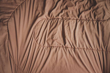 Brown blanket, soft and warm fabric crumpled in folds. texture for background. top view