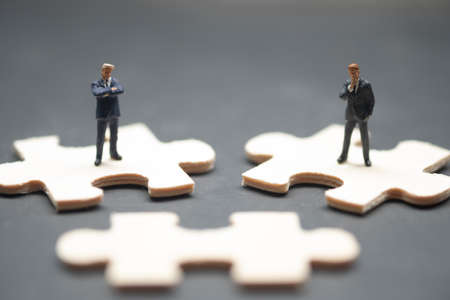 Two of miniature businessman stand on wood jigsaw. Business vision concept.の写真素材