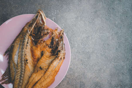 Close up deep fried sea bass With Fish Sauce (Pla Ga Pong Tod Nam Pla) in the pink plate