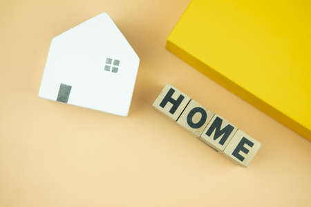 Miniature house and wooden blocks with the word home. Real estate concept.の写真素材