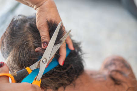 Wife use scissors and comb cut husband at home during  pandemic restrictions.