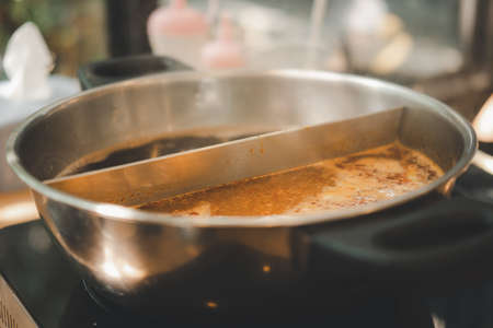 Sukiyaki of two ways in the hot pot. Close up on tom yum soupの写真素材