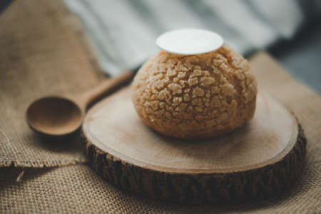 Delicious homemade small Choux Cream placed on round wooden
