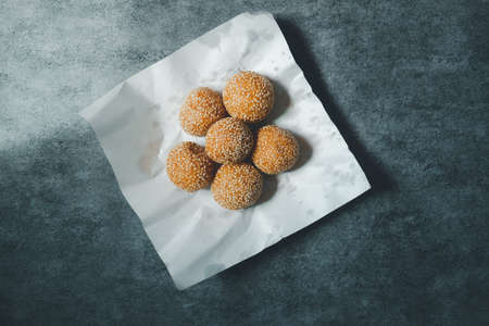Sesame balls stuffed bun fried coated with white sesame on paper bag, Traditional Thai dessertの写真素材