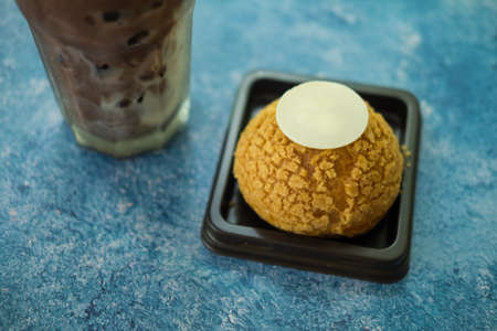 Choux Cream in box and a glass of iced coffeeの写真素材