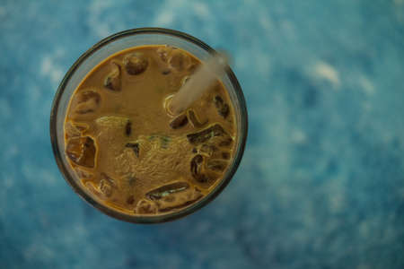 Frozen coffee in glass on blue background. Top viewの写真素材
