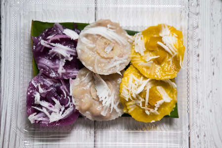 Thai steamed banana cake, pumpkin cake and purple sweet potato with shredded coconut in boxの写真素材