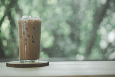 iced mocha coffee glass cup in cafe restaurant against nature backgroundの写真素材