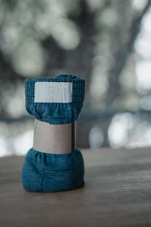 Rolled blue folded men boxer briefs with brown paper on tableの写真素材