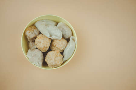 Steam of fish balls, shrimp balls and pork balls in yellow bowl, ready to eatの写真素材