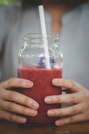 Female holding refreshing blended fruit smoothie drink. Refreshing drinkの写真素材