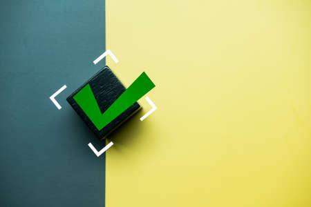 Check mark on a black wooden block. The concept of choice and making the right decision. Business management.の写真素材