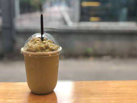 Coffee frappe in take away glass on wood tableの写真素材