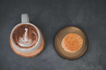 Hot mocha coffee with latte art and scone. Top viewの写真素材