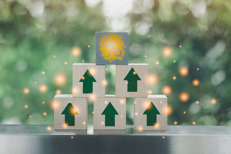 Wood block stacking as pyramid with arrow up and percentage icon wooden block on top pyramid. Business growth conceptの写真素材