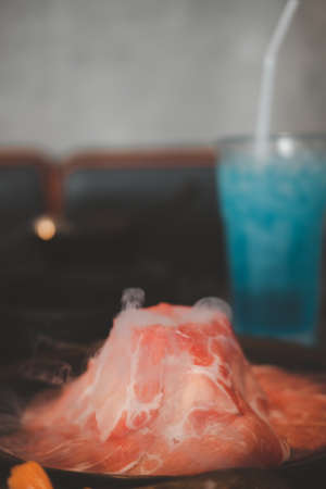 Fresh pork slices decoration with dry ice. Close up