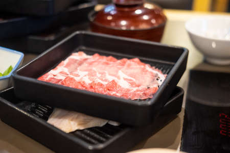 Slice beef in black tray prepared for shabu or sukiyaki or Japanese hot pot. Selective focusの写真素材